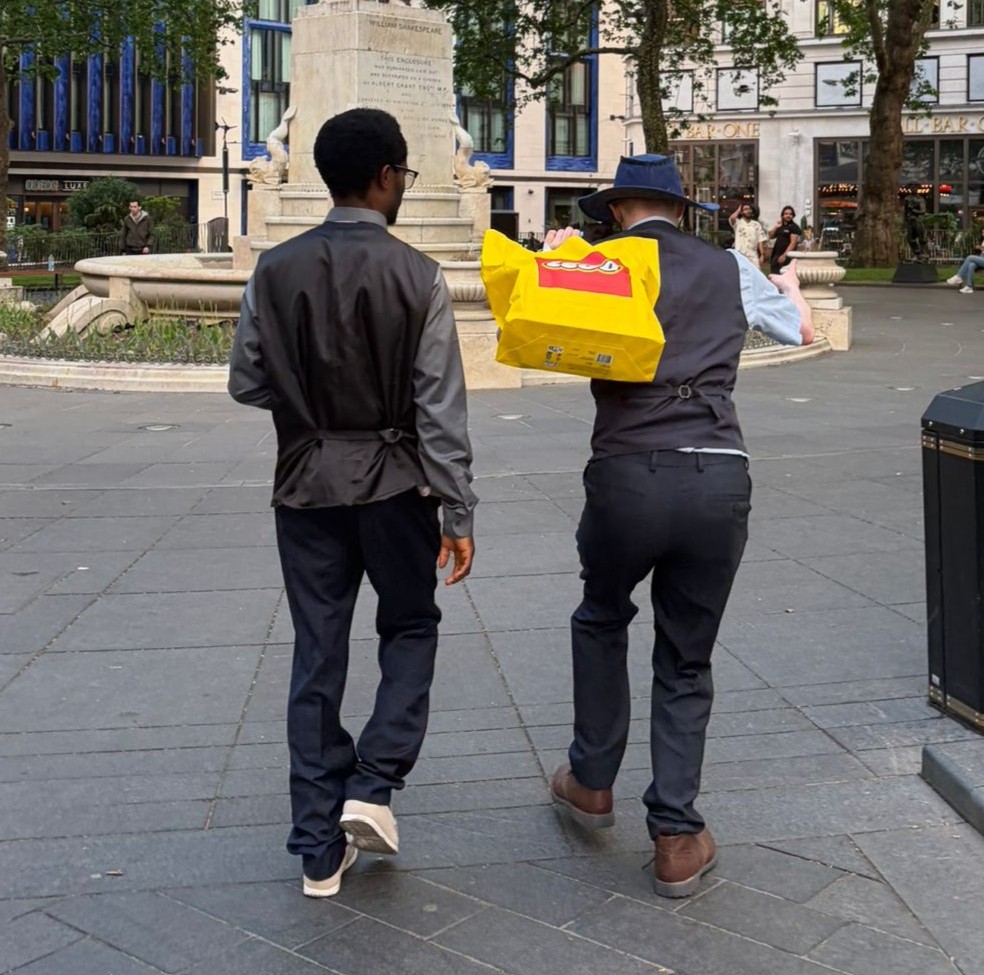 Two people walking together through a city square after a shopping trip