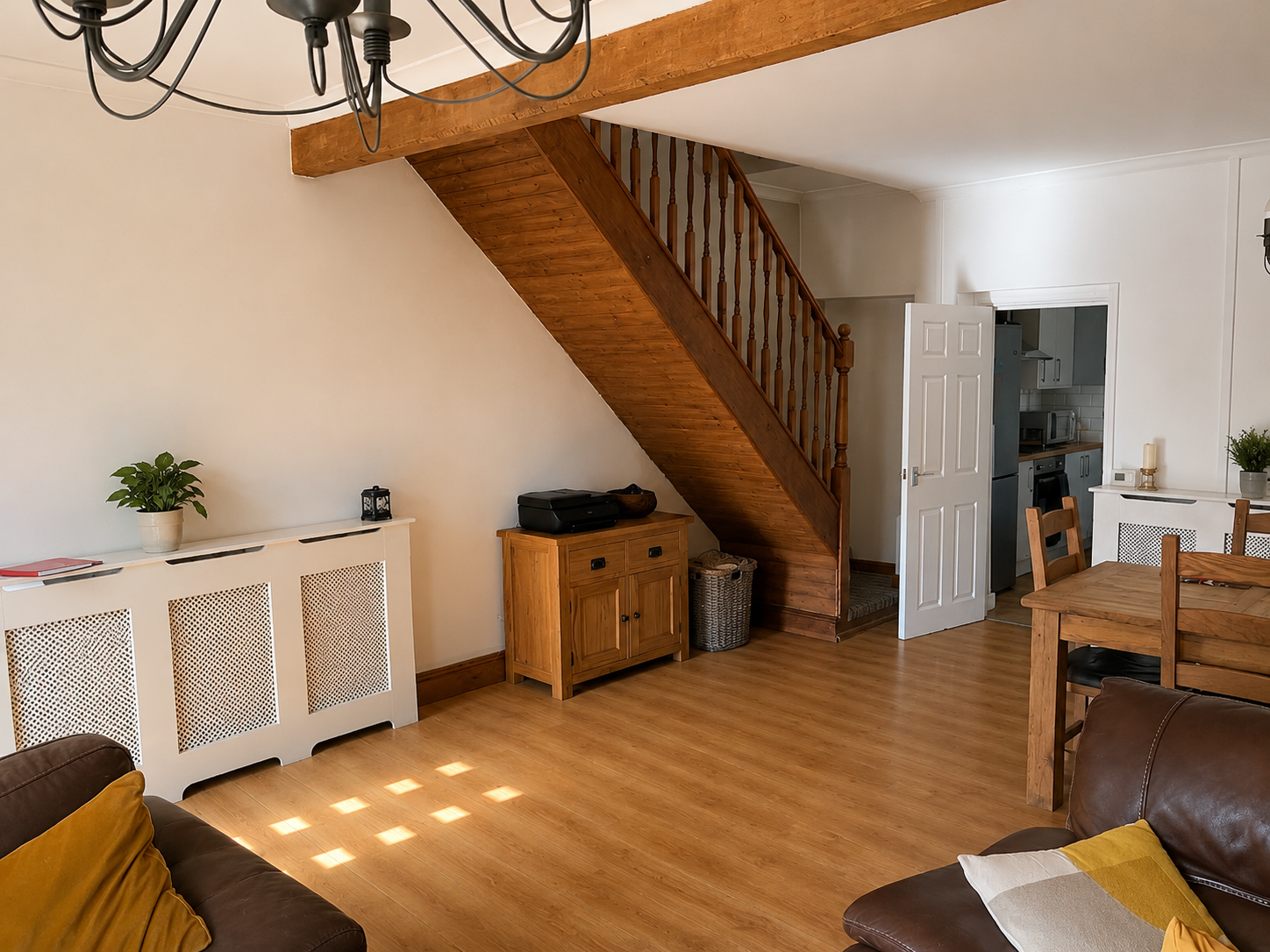 Riverside House main lounge with wooden staircase and dining area