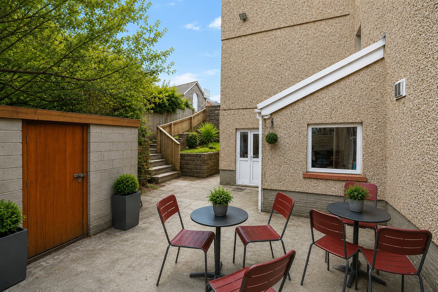Woodlands House rear patio with outdoor seating and landscaped steps