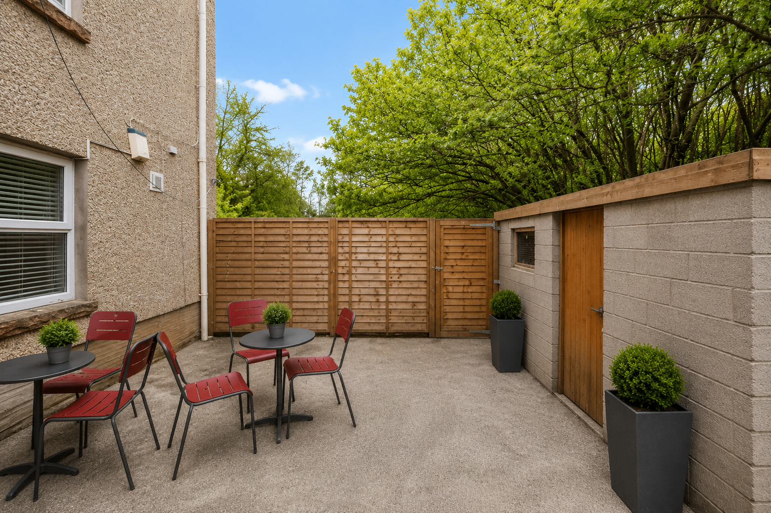 Woodlands House enclosed back garden patio with seating and planters