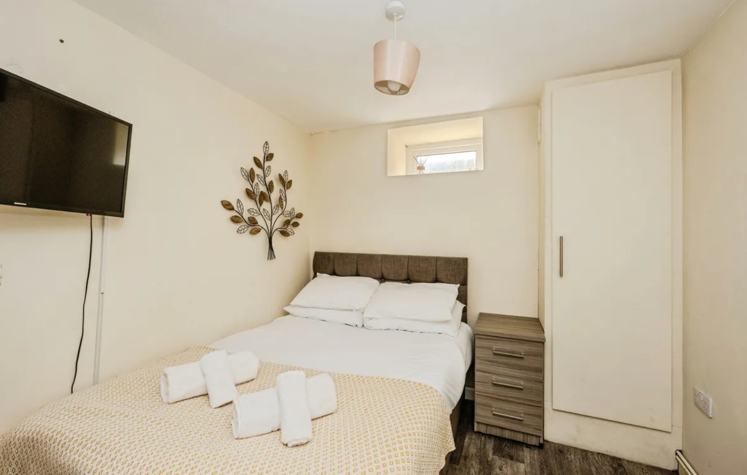 Woodlands House bedroom with double bed and wall-mounted television