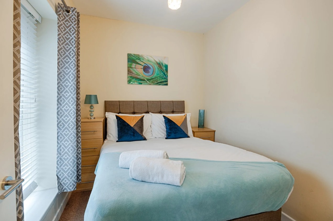 Woodlands House bedroom with teal throws and cushions