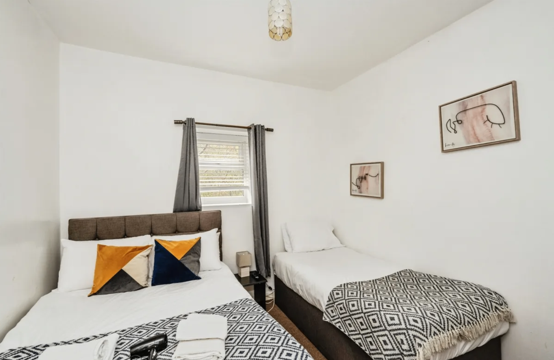 Woodlands House twin bedroom with two single beds and framed artwork
